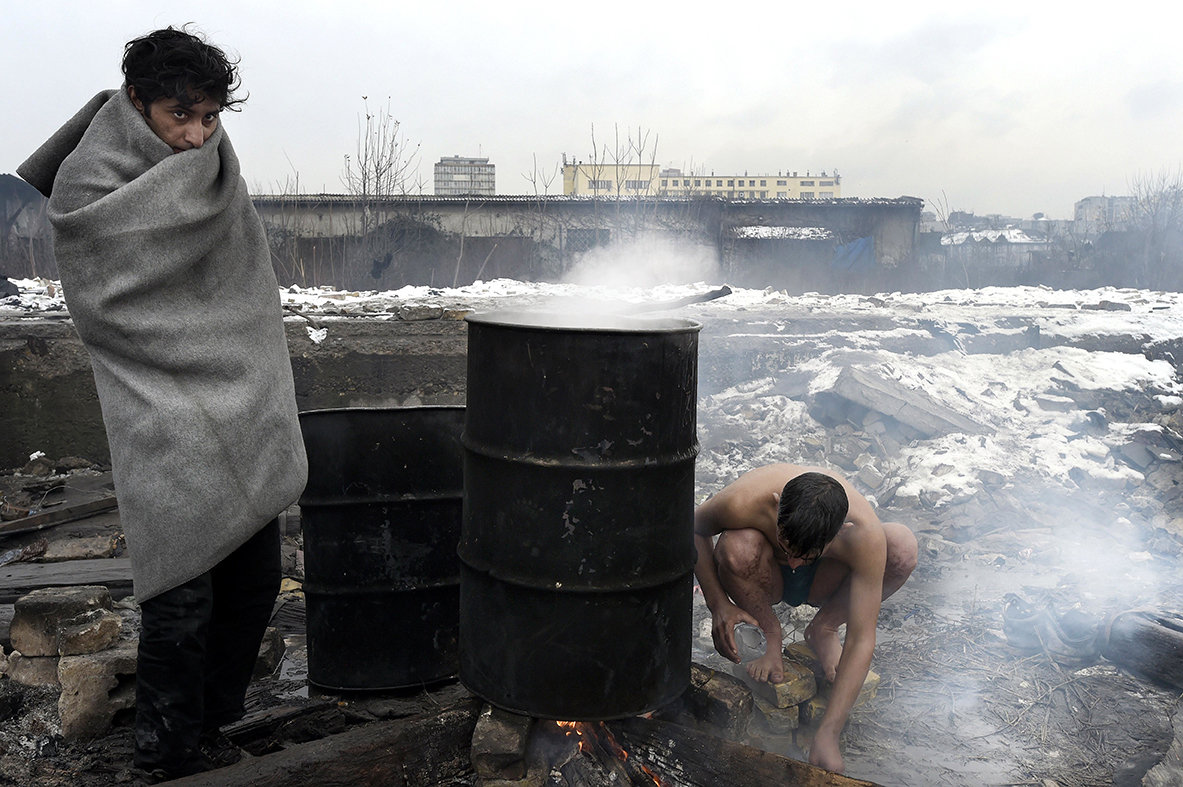 Flüchtlinge in Belgrad erhitzen mit Feuer Wasser in einem Fass (Foto: picture alliance / Photoshot)
