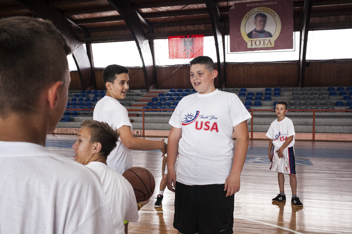 Kinder in USA-Shirts auf einem Basketball-Platz