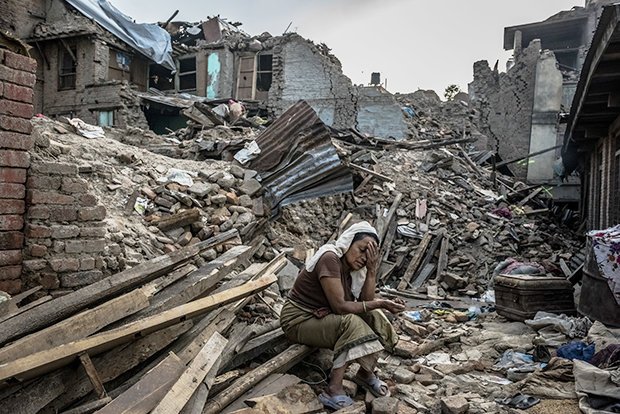 Nach dem schweren Erdbeben sitzt eine nepalesische Frau zwischen den Trümmern ihres Dorfes (Foto: DANIEL BEREHULAK/NYT/Redux/laif)