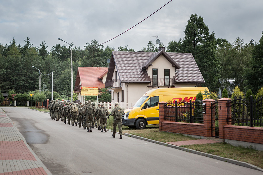 Die paramilitärischen Strzelec marschieren für ihre militärische Übung in einem Wald durch eine Neubausiedlung in Mrozy, ein kleiner Ort rund 1,5 Sunden östlich von Warschau