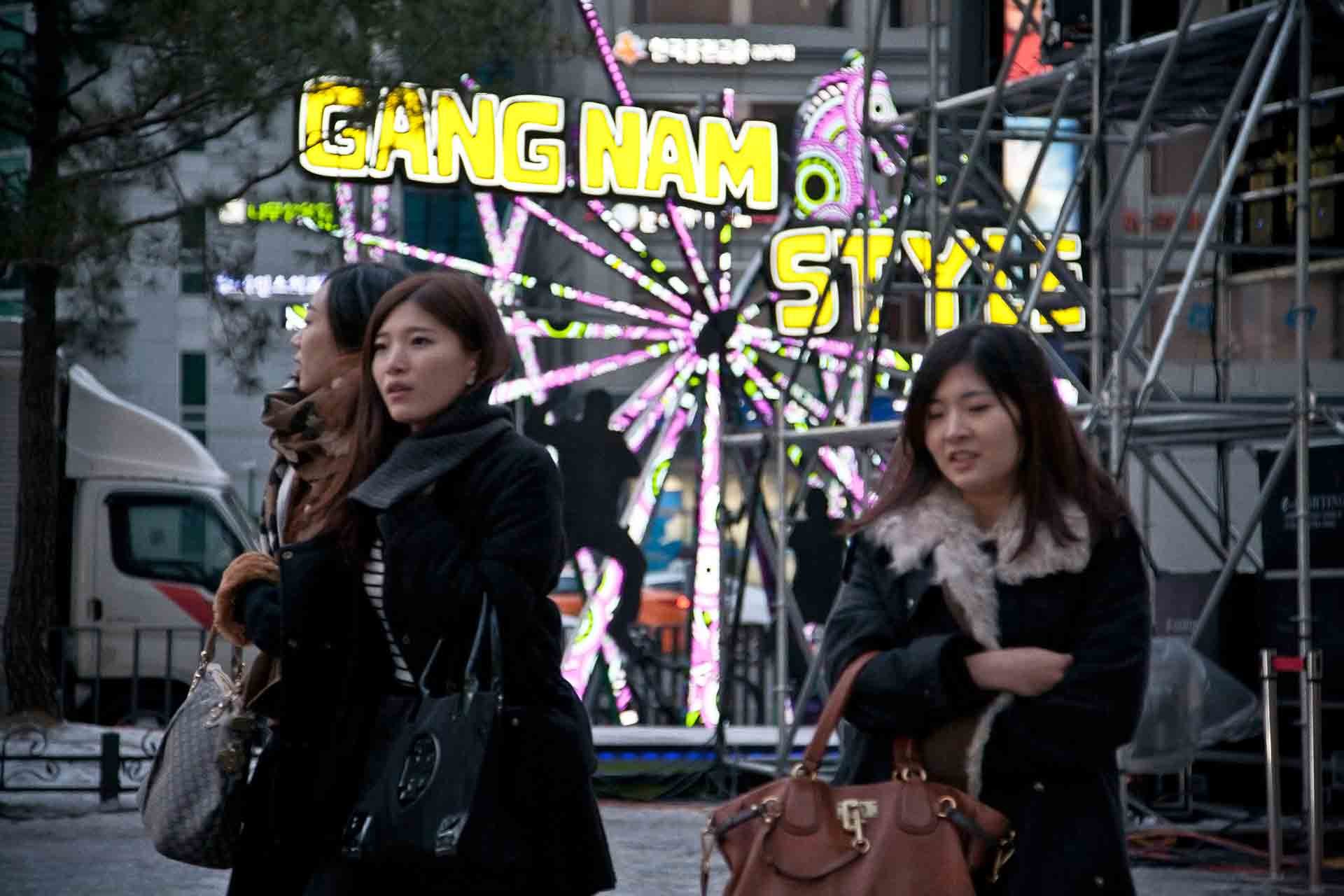 Koreanische Jugendliche in Seoul vor einem Denkmal für den Song Gang Nam Style