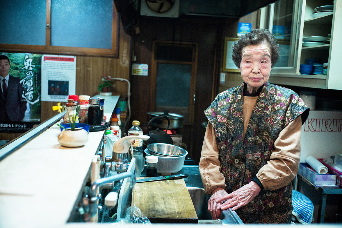 Alte Frau bedient in einem Imbiss in Tokio