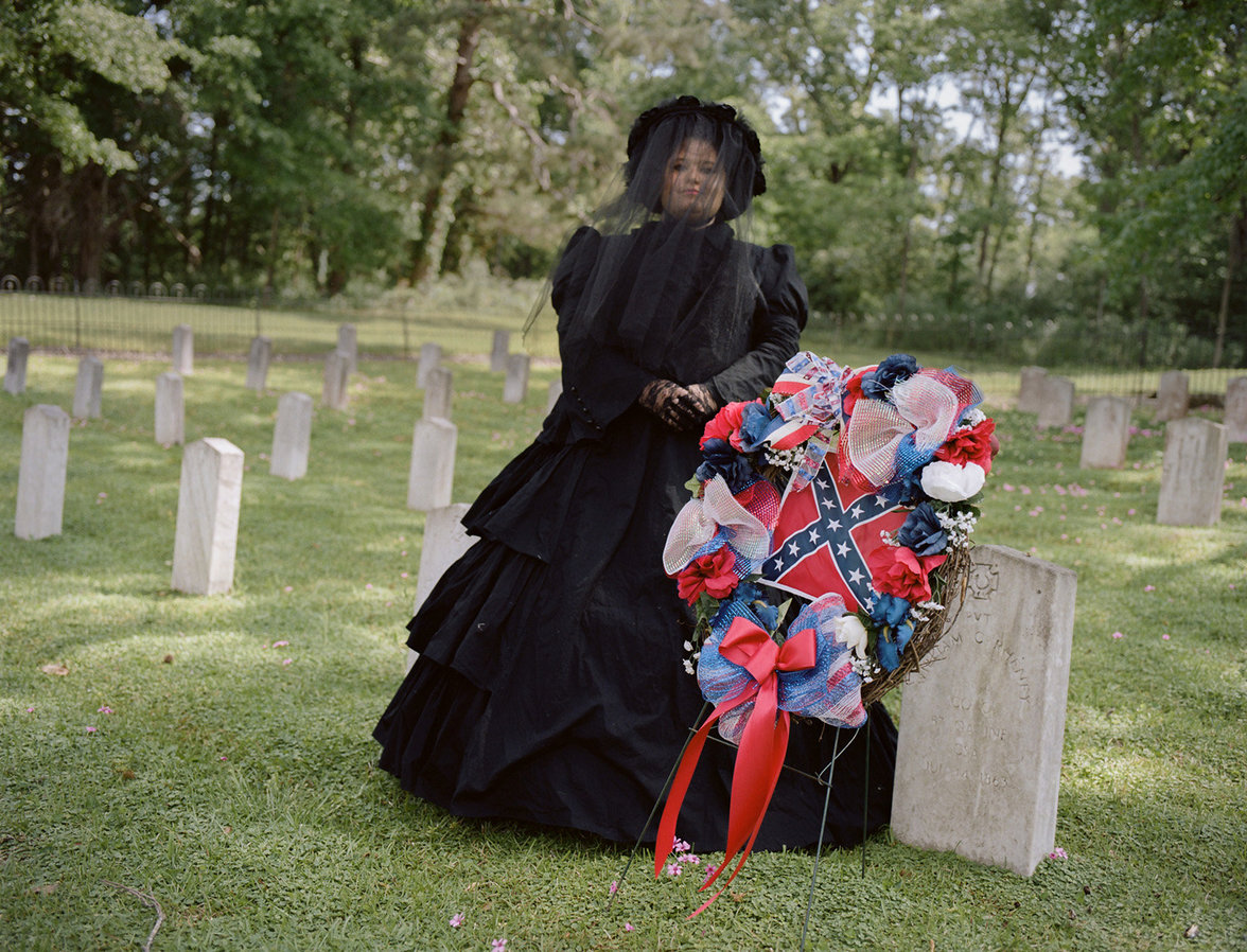 Tara Bradley posiert in einem Trauerkleid neben der Kriegsflagge der Konföderierten Staaten von Amerika