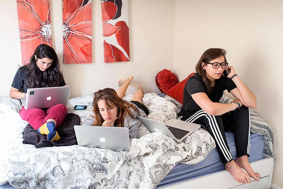 Junge Frauen mit Laptops im Bett