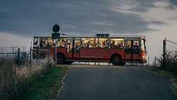 Arbeitskräfte kommen am frühen morgen mit einem alten Bus auf einer Apfelplantage in Sachsen an