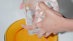 Eine Hand hält einen großen Eiswürfel über einem Teller (Foto: Moritz Jekat)