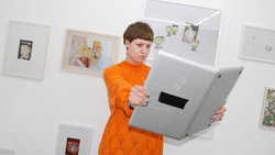 Eine Frau hält einen Laptop wie ein Buch 