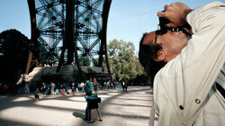 Ein Tourist fotografiert den Eiffelturm von unten