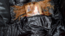 Rothaarige Frau mit einem Portrait auf dem Gesicht im Bett