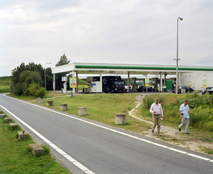 Trampelpfad, der sich neben einer Tankstelle für Fußgänger gebildet hat