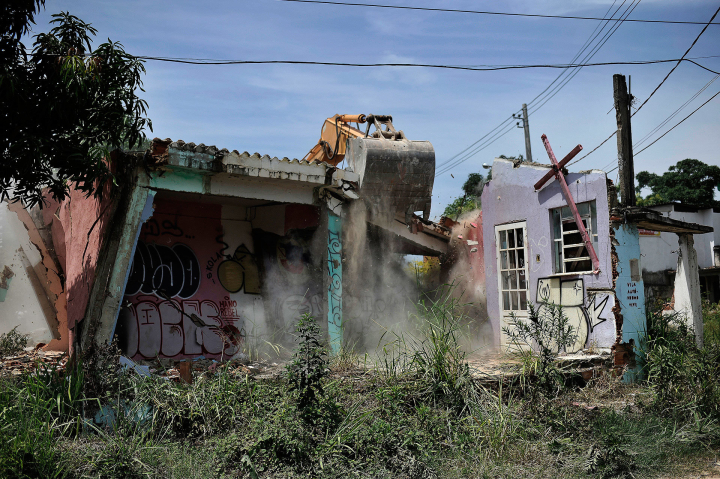 Bagger reißt ein Gebäude ab in einer Favela in Rio de Janeiro, die für die Olympiade weichen muss