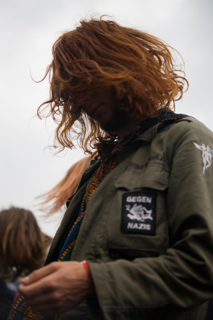 Festivalbesucherin mit Parka, das Gesicht vom langen Haar verdeckt