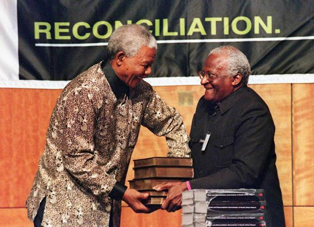 Am 29. Oktober 1998 übergibt der Vorsitzende der Wahrheitskommission Erzbischof Desmond Tutu dem südafrikanischen Präsidenten Nelson Mandela den fünfbändigen Abschlussbericht