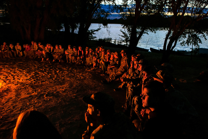 Youngsters participating to the ultra-nationalistic Azovets children's camp are sitting together around the evening fire