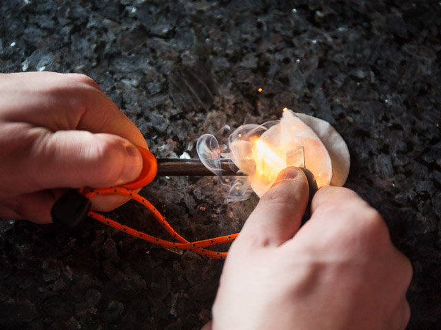 Mit einer Art Wetzstahl entfacht Bastian Blum Funken, die ein Wattepad schnell zum Brennen bringen – optimal, um mit Zunder und Holz schnell ein Feuer zu entfachen