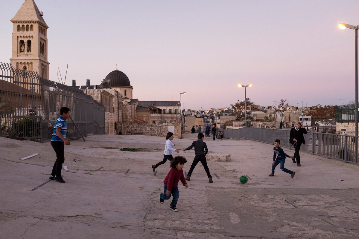 A group of Palestinian boys play football on the rooftops. 