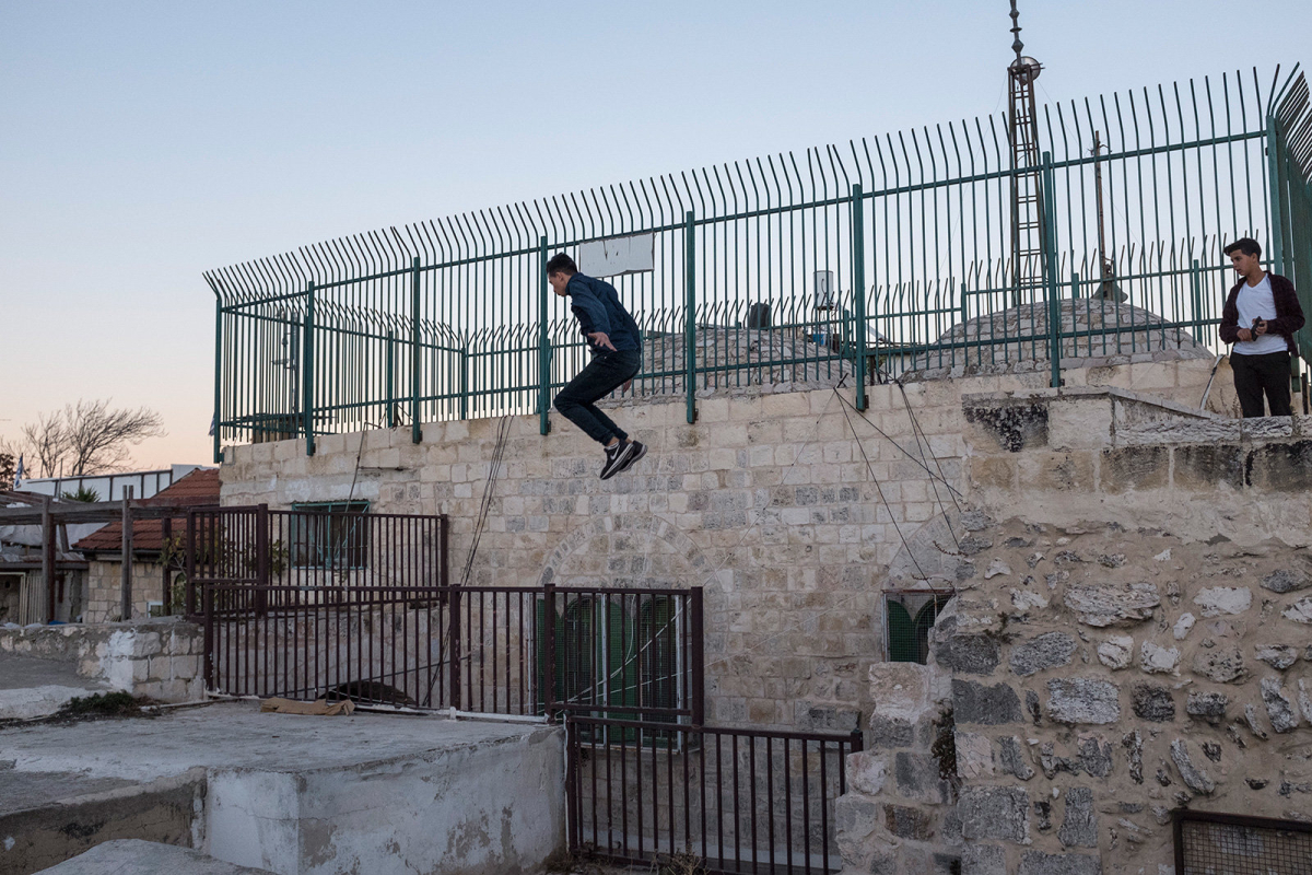 A Palestinian teenager jumps from one roof to another performing parkour.  The group of athletes uses to gather and practice on Friday and Sunday afternoon. 