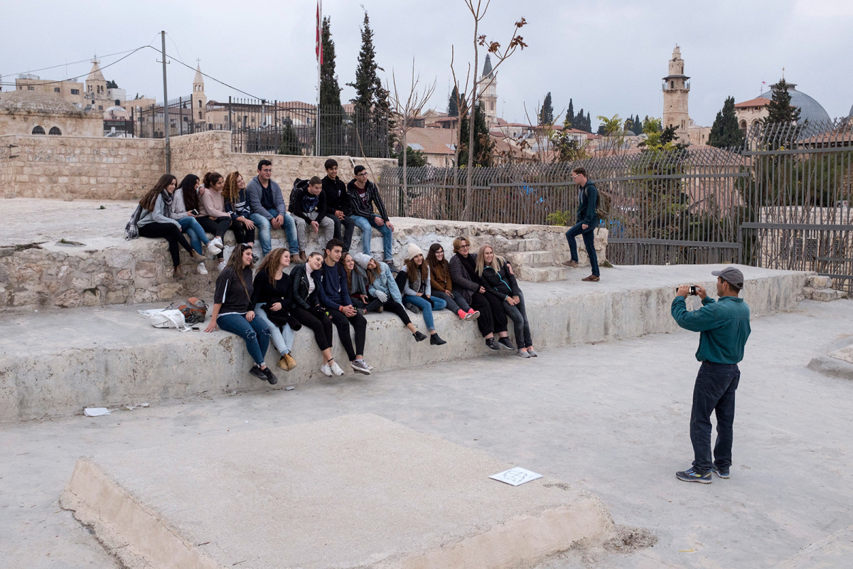 A group of students are portrayed during a visit on the roof tops walk.