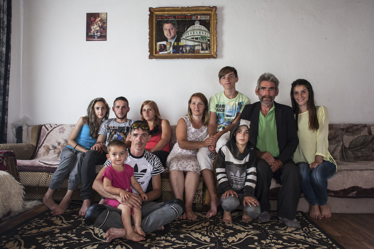 Klinton Bajgora, 13 years old, siting between his parents, poses for a portrait together with his family at their home in the countryside of Podujevo, Kosovo. He was named Klinton in honor of Bill Clinton, to whom his father feels a great devotion due to 