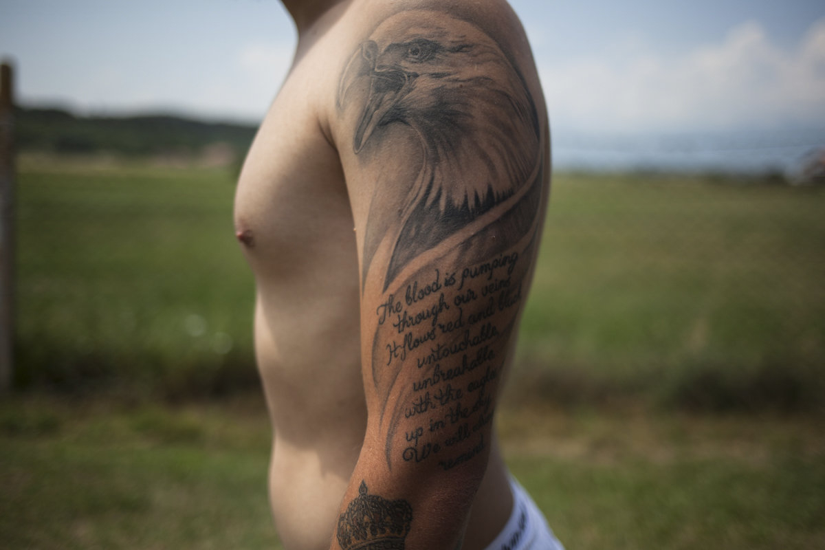 Arlind Basha wears on his left arm a tattoo of an eagle with verses that refer to the Albanian-Kosovar national identity, written in English. The eagle is a patriotic symbol for both Albanians and Americans, with the difference that the Albanian eagle sym