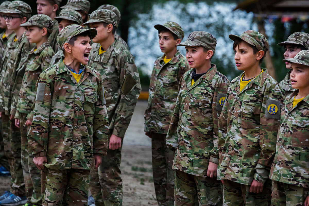 At the call of a team's leader, youngsters participating to the ultra-nationalistic Azovets children's camp are responding with their team's slogan, during a regular ceremony - starting and ending the day