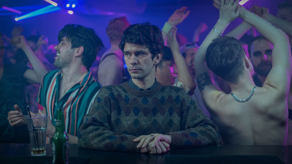 Adam (Ben Whishaw) sitzt emotionslos an einer Bar und schaut nach vorne, während auf der Tanzfläche hinter ihm alle ausgelassen tanzen. Adam (Ben Whishaw) sitzt emotionslos an einer Bar und schaut nach vorne, während auf der Tanzfläche hinter ihm alle ausgelassen tanzen.