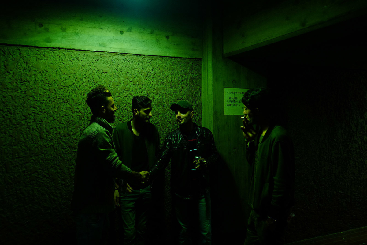 A group of young kurdish friends smoking cigaretttes and drinking beers after a kurdish wedding party