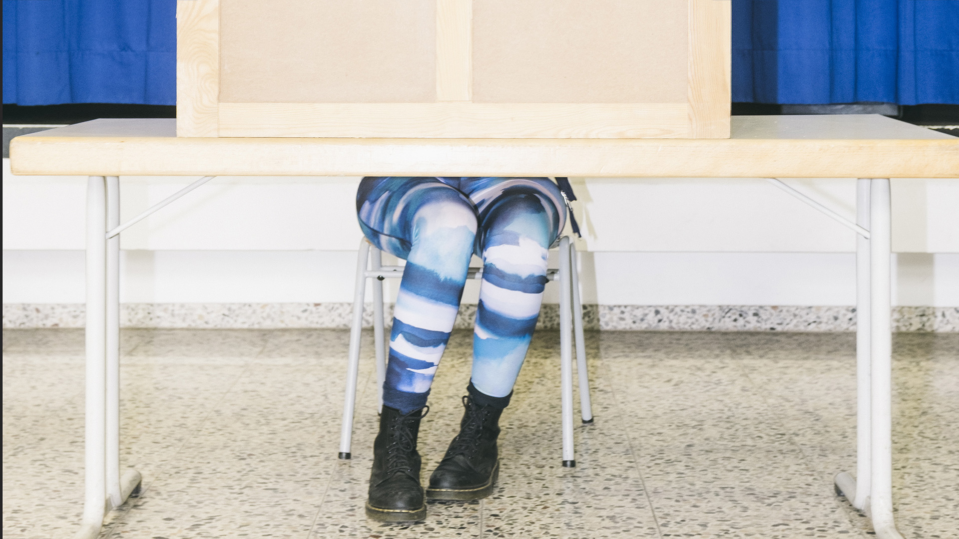 Die Beine einer Frau schauen aus einer Wahlkabine. Foto: Hannes Jung / laif