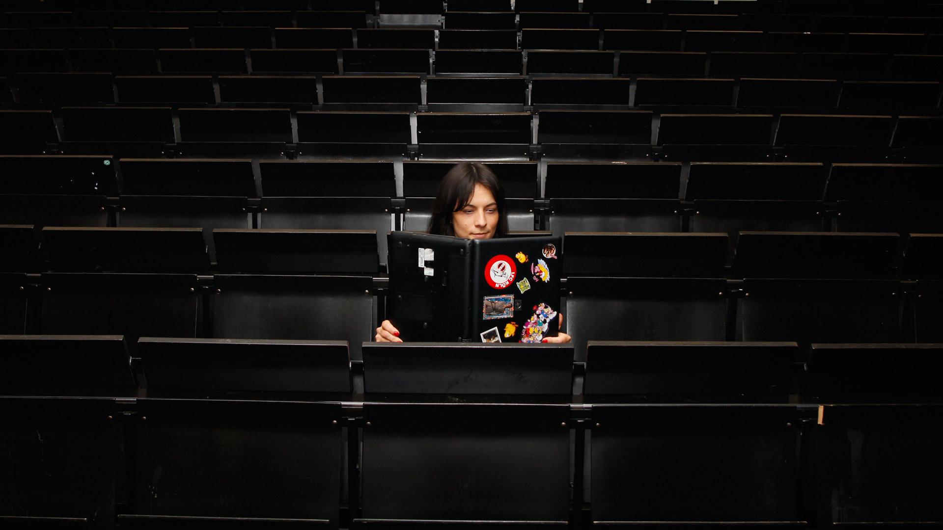 Frau liest in aufgeklapptem Laptop Frau liest in aufgeklapptem Laptop