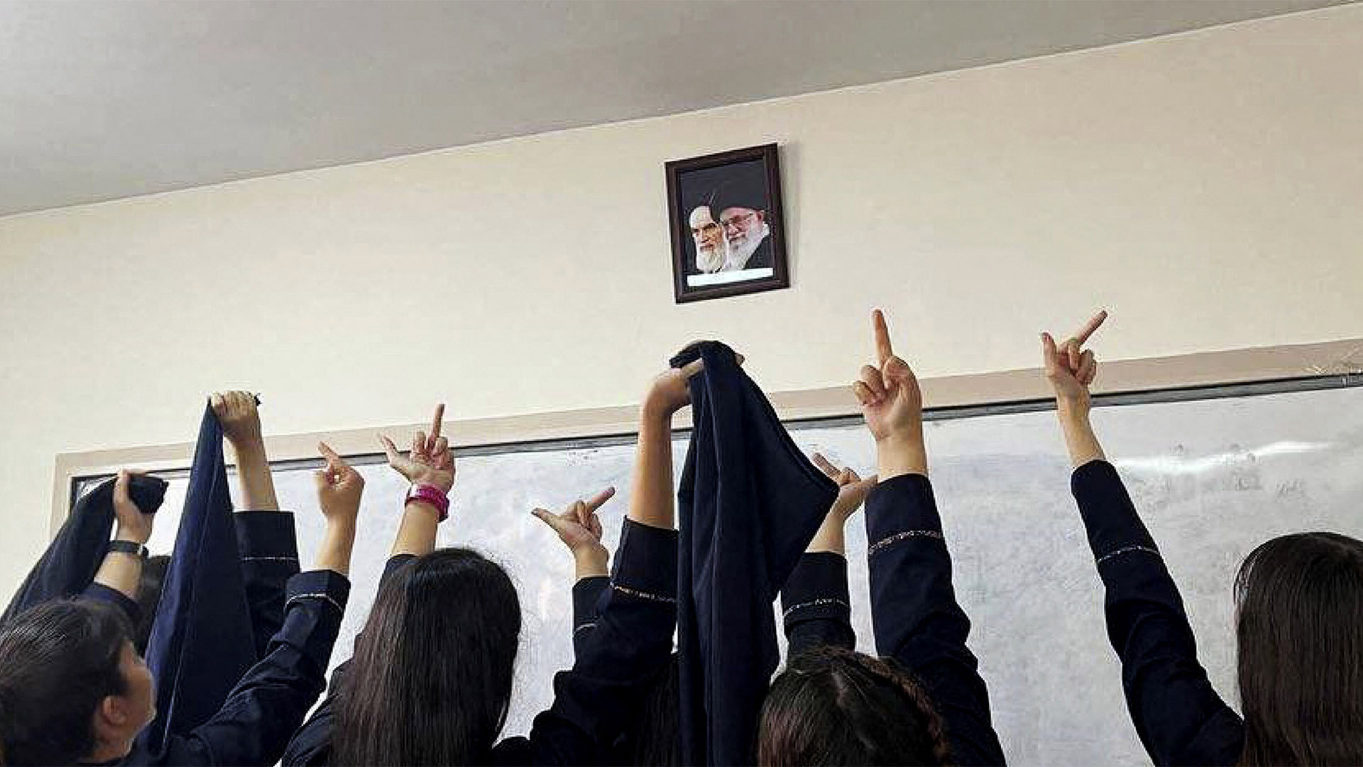 In einer Schule zeigen Mädchen ohne Kopftuch dem geistlichen Führer, was sie von ihm halten In einer Schule zeigen Mädchen ohne Kopftuch dem geistlichen Führer, was sie von ihm halten