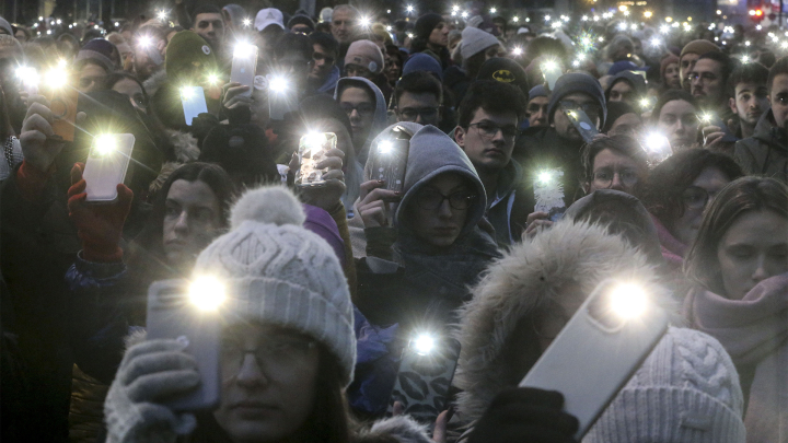Demonstrantinnen halten ihre Handylampen hoch