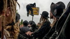 Ein Zimmermann klettert über das Orstschild