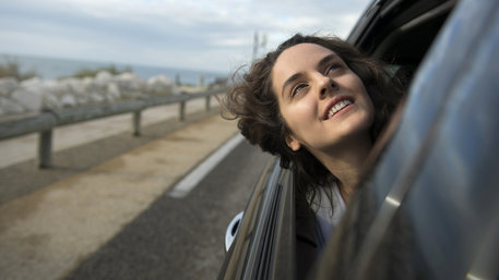 Die Protagonistin Sonia (Noémie Merlant) streckt den Kopf aus dem Autofenster und blickt Richtung Himmel