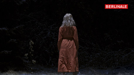 Eine Frau mit rotem Kleid im Wald