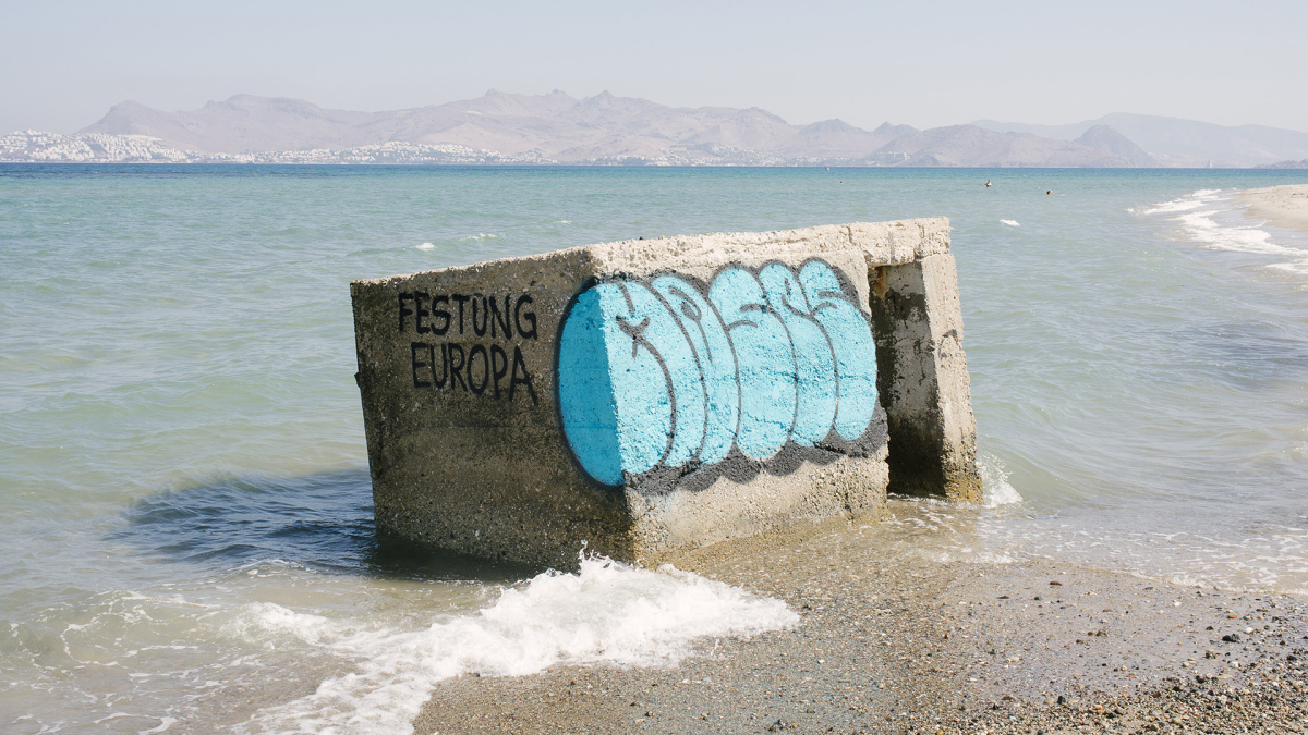 Überreste aus Beton im Mittelmeer mit der Aufschrift "Festung Europa". Foto: Jörg Brüggemann/OSTKREUZ