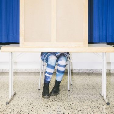 Die Beine einer Frau schauen aus einer Wahlkabine. Foto: Hannes Jung / laif