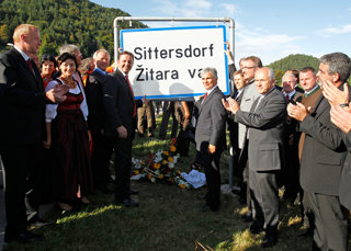 August 2011: Sogar der österreichische Kanzler kommt zur Montage der Ortstafel in Sittersdorf / Zitara vas