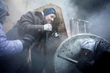 Auf dem Maidan in Kiew schützen sich Demonstranten mit selbst gebastelten Schildern gegen das hochgerüstete Militär