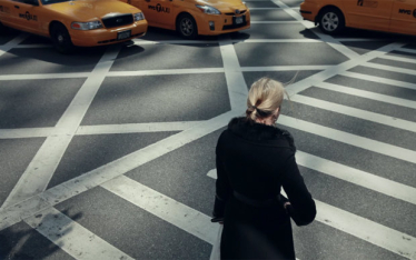 Eine Frau in überquert einen Zebrastreifen in New York Eine Frau in überquert einen Zebrastreifen in New York