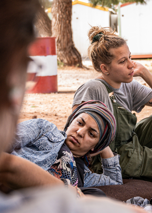Drei Frauen chillen auf dem Boden im Flüchtlingscamp
