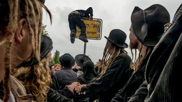 Ein Zimmermann klettert über das Orstschild