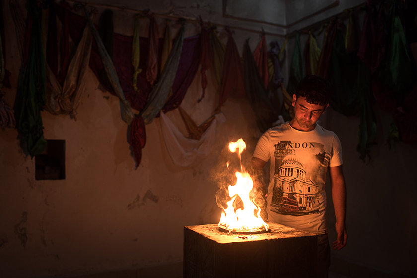 Ein junger jesidischer Mann vor einem Feuerschrein (Foto: Chris Grodotzki)