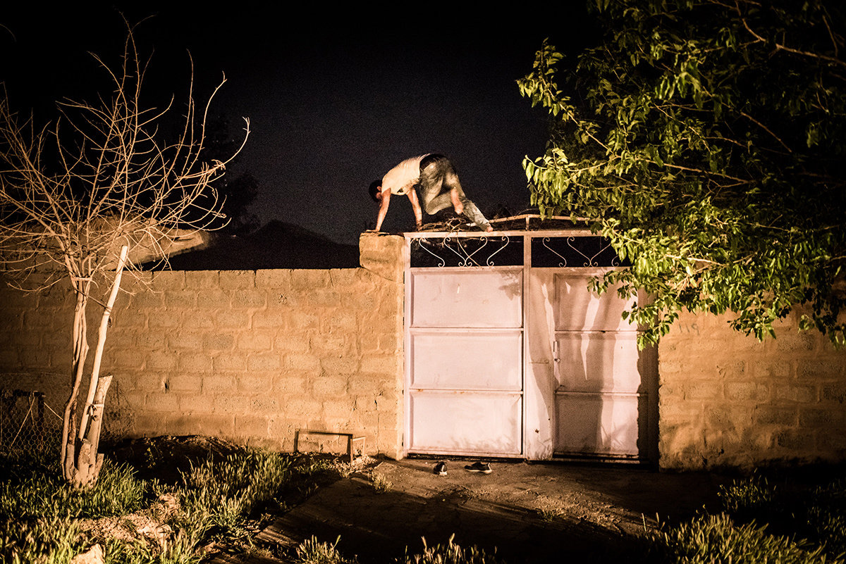 Ein junger Mann springt bei Nacht über ein Tor (Foto: Chris Grodotzki)